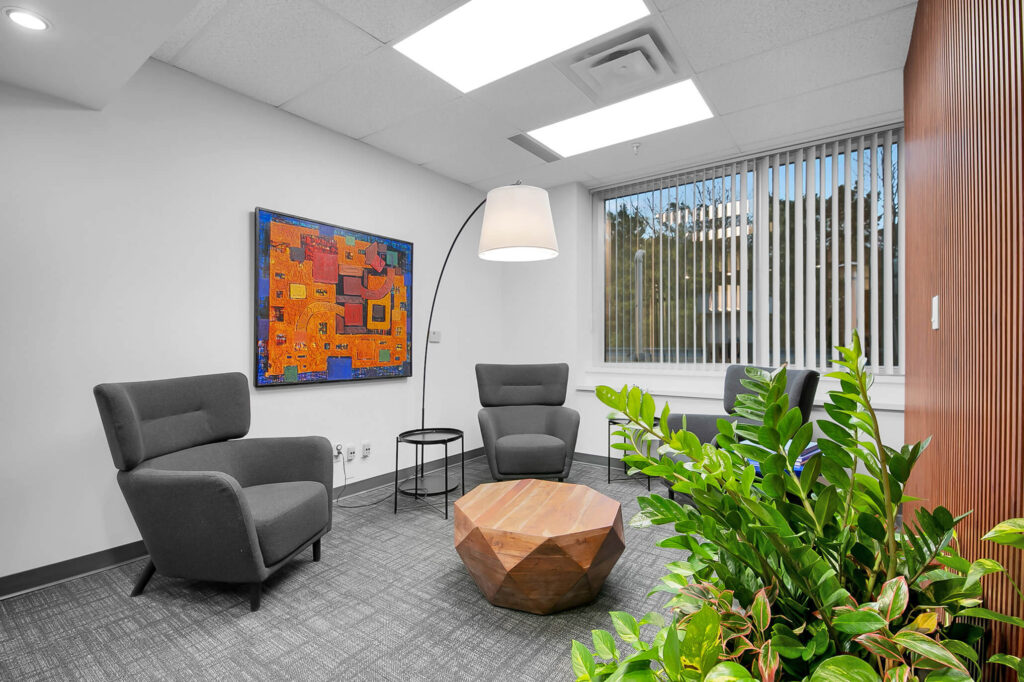 Office with two chairs, a table, and lamp